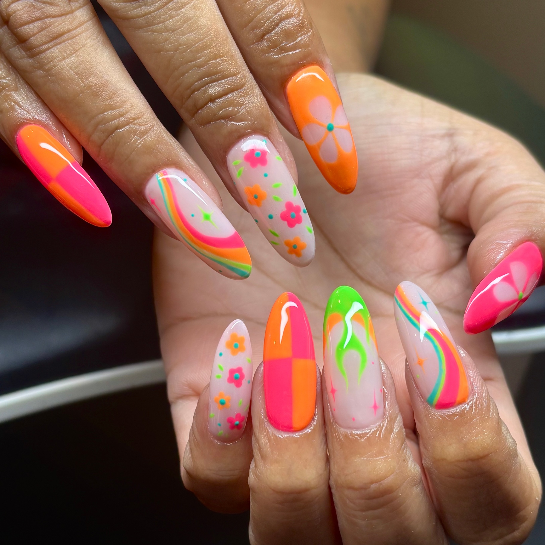 Neon mixed nail art with flowers, swirls, and color blocking