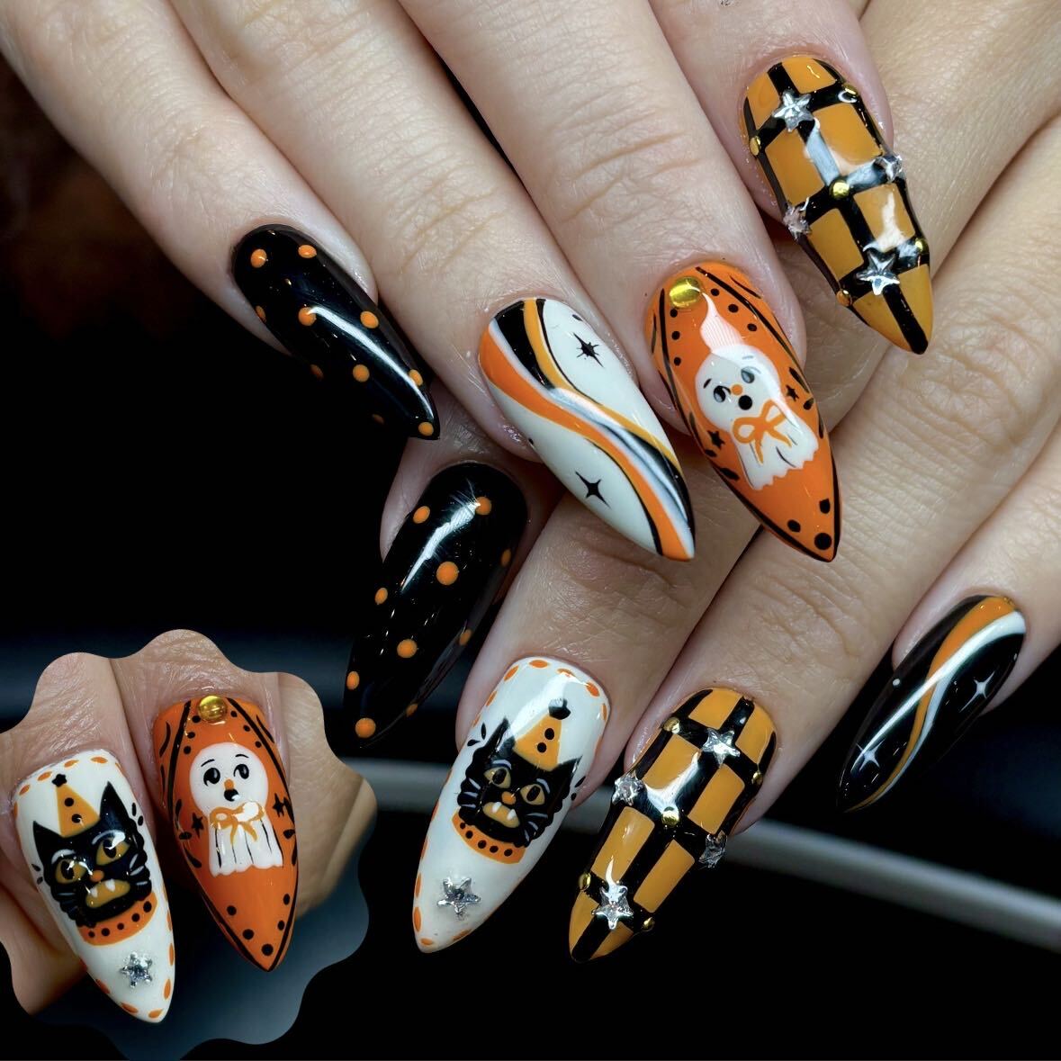 Halloween nail art with ghosts, black cats, orange checks, and silver stars by 'Cure Studios