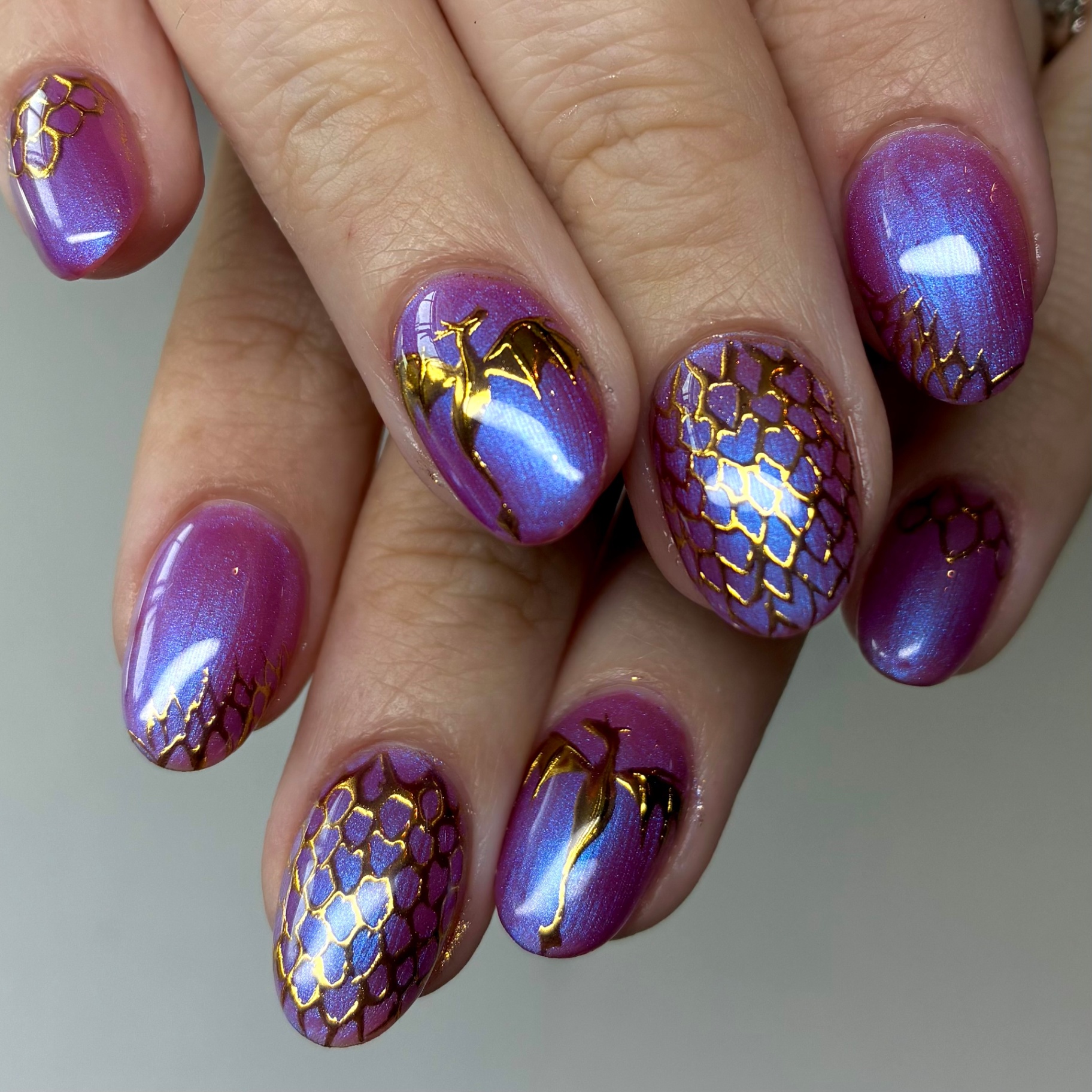 Iridescent purple nails with gold foil scale detailing