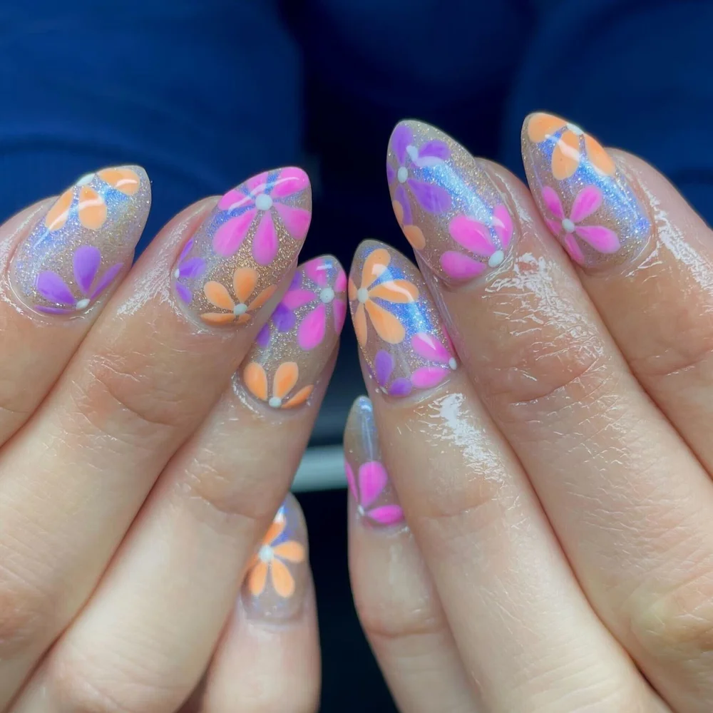Purple and orange hand-painted daisy nail art on almond nails