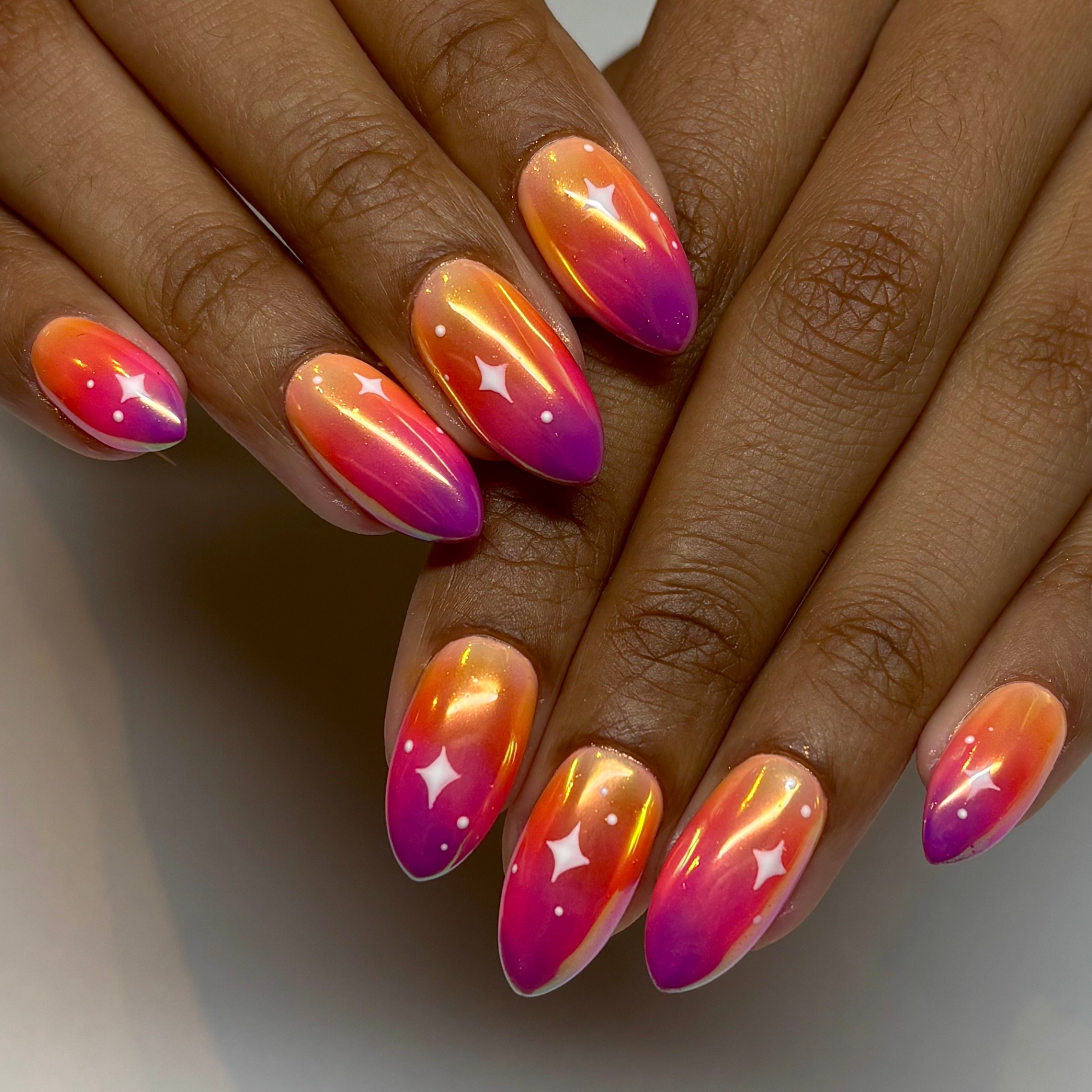 Sunset ombre chrome nails with white star accents