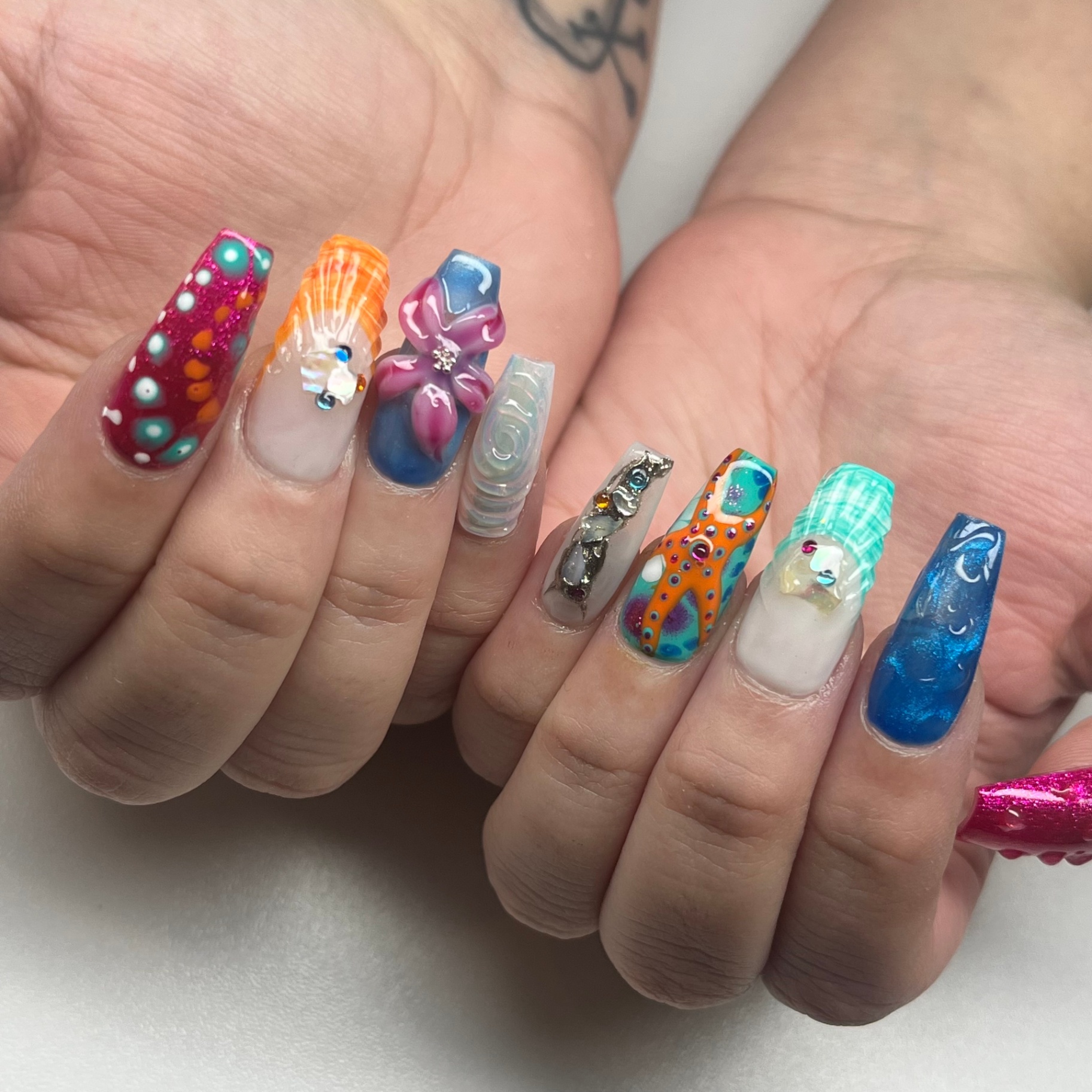 Mixed ocean-themed nail art with 3D florals and rhinestones
